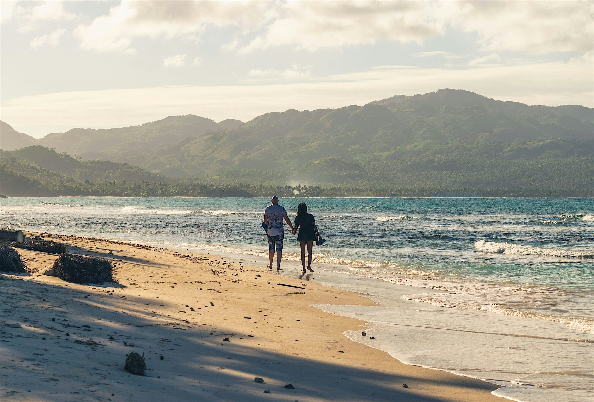 Couple walking on a quiet beach holding hands