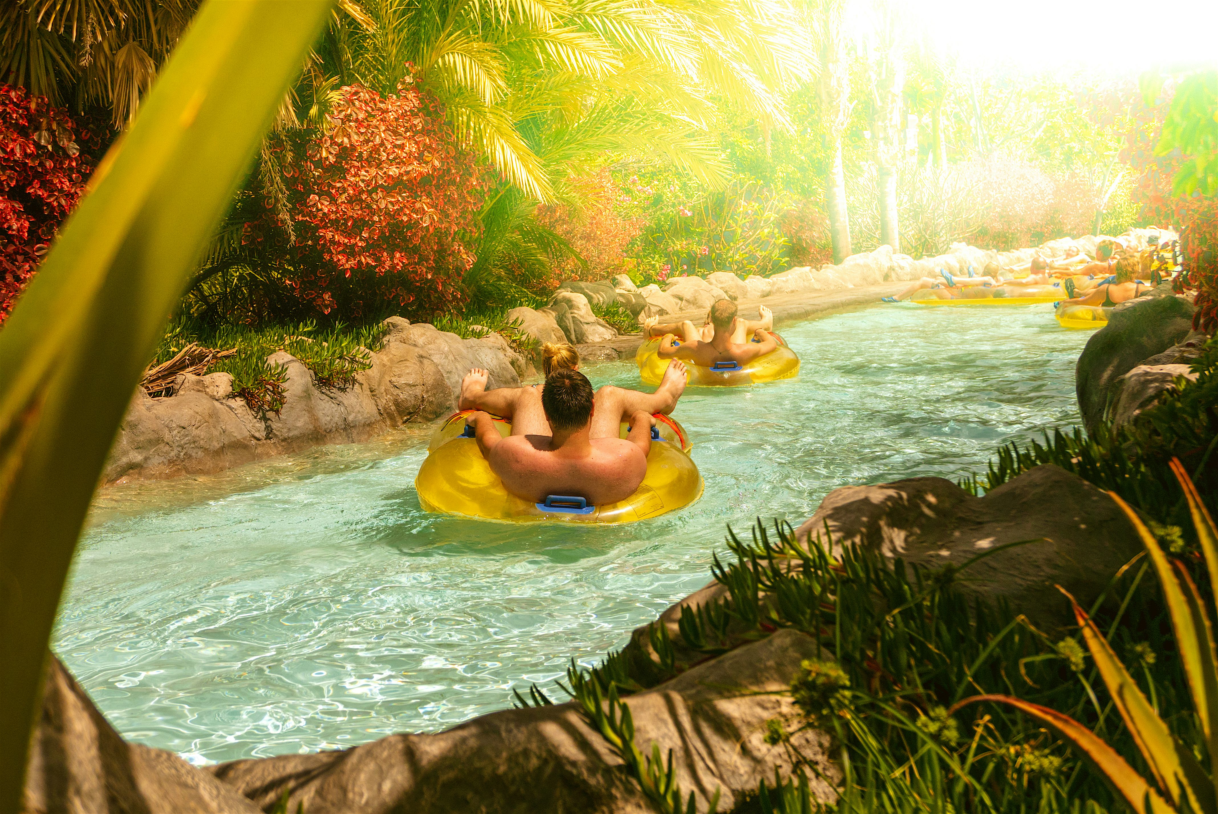 Mai Thai River at Siam Park. People floating on the lazy river surrounded by tropical landscaping.