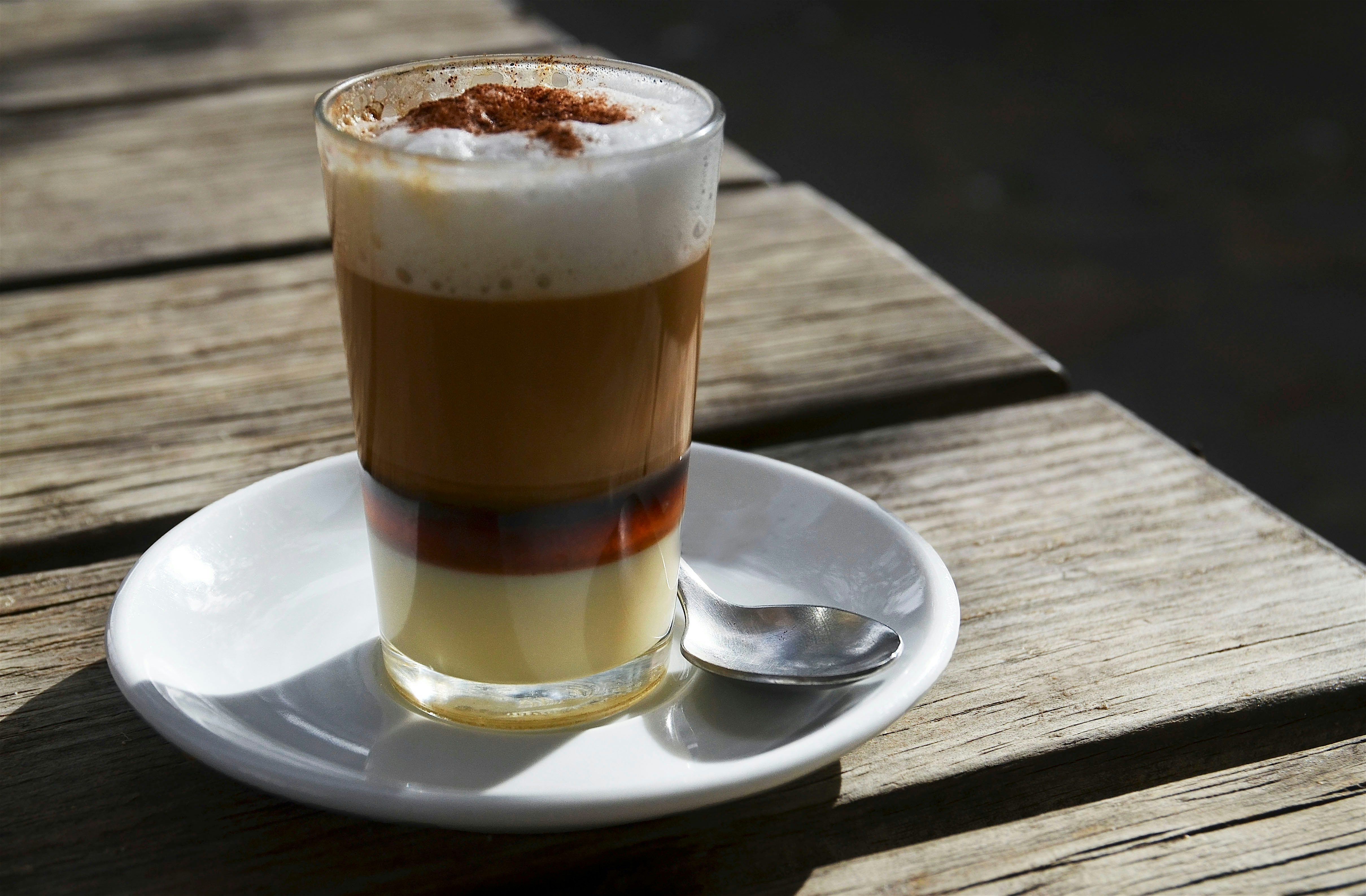 Barraquito, a multi- layered coffee liqueur drink garnished a sprinkle of ground cinnamon