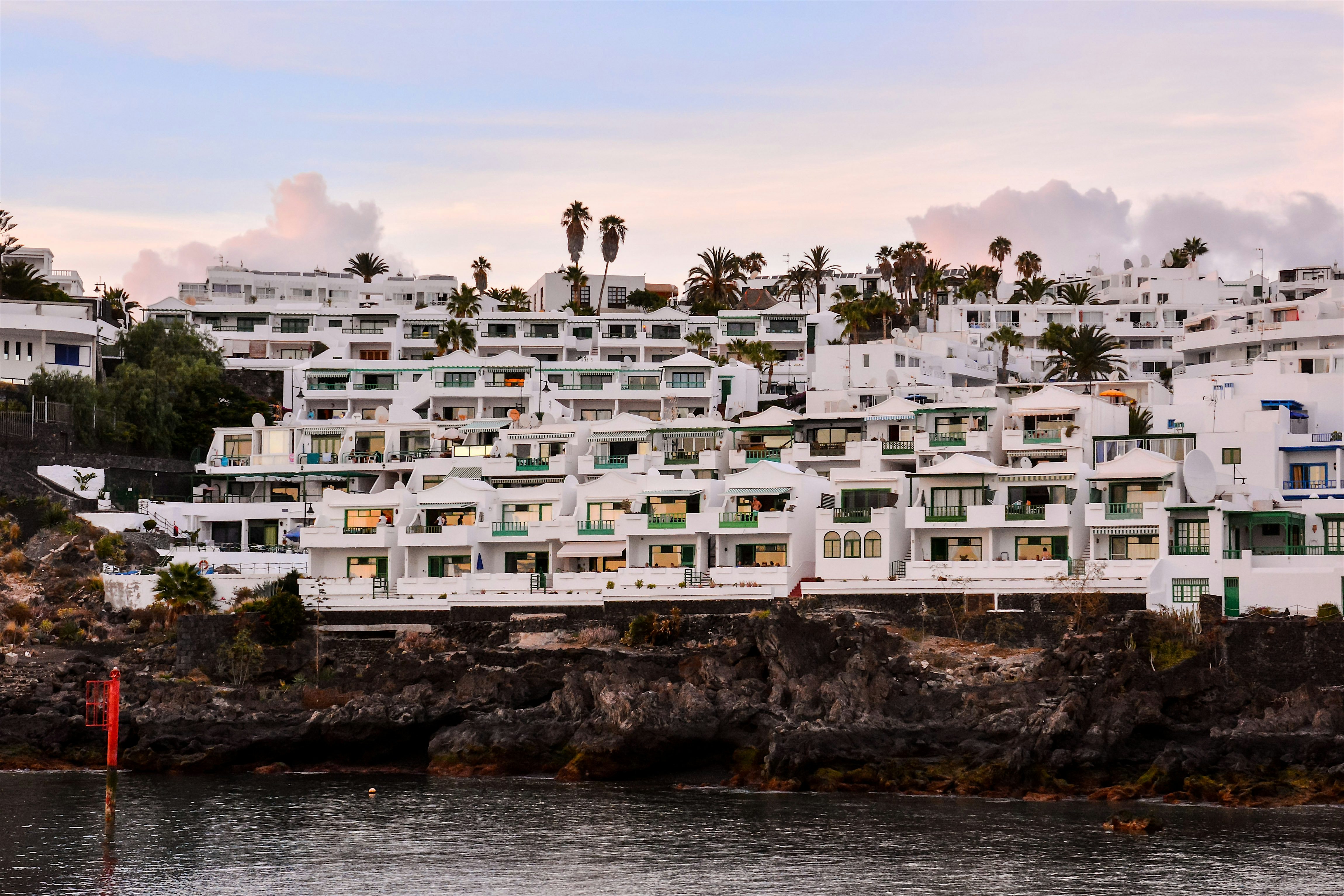 Coastal whitewashed buildings built into the black volcanic rock.