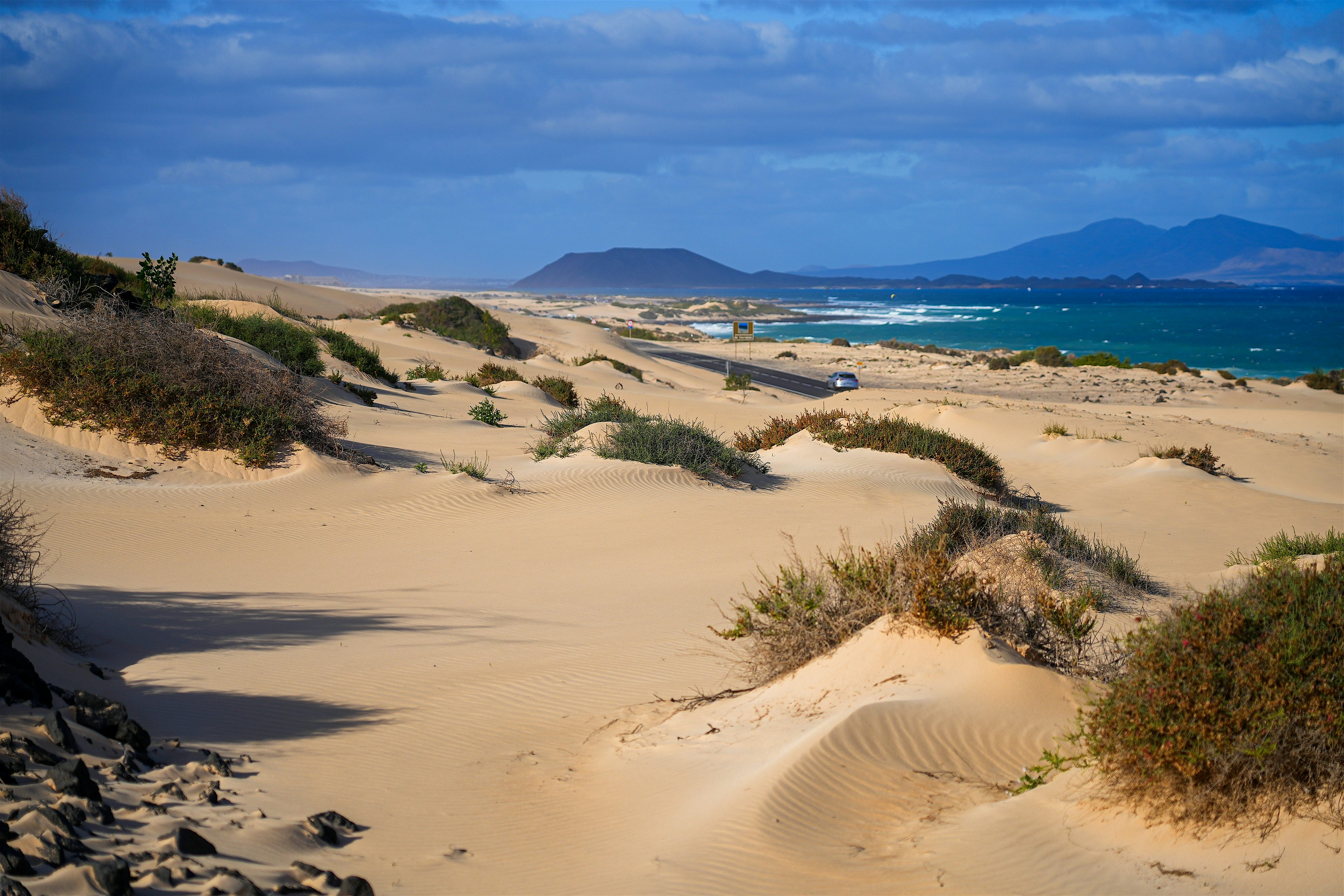 El Jable sand dunes adjacent to the Atlantic Ocean  volcanic landscapes in the background