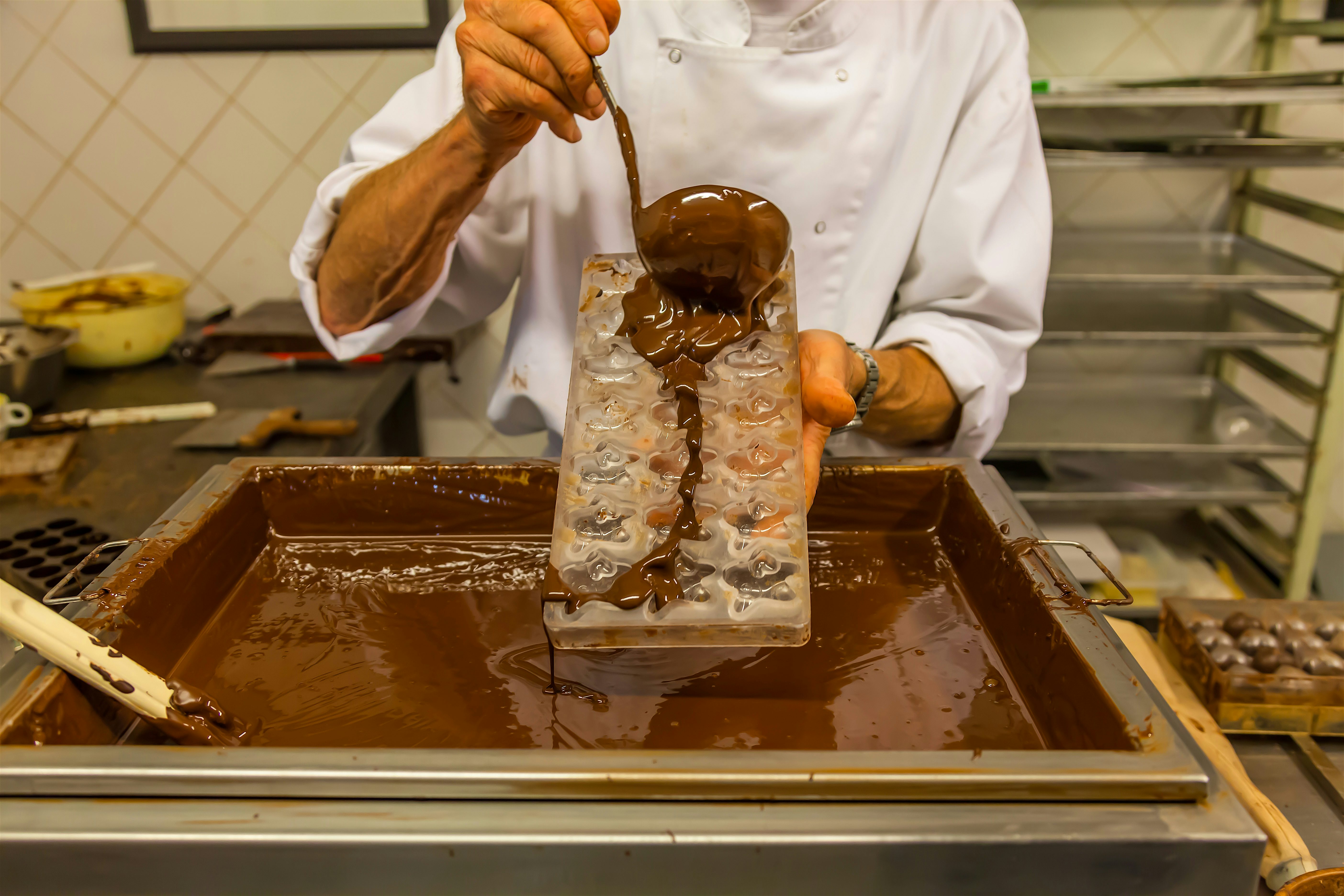 Chocolate being poured over a Belgian waffle.