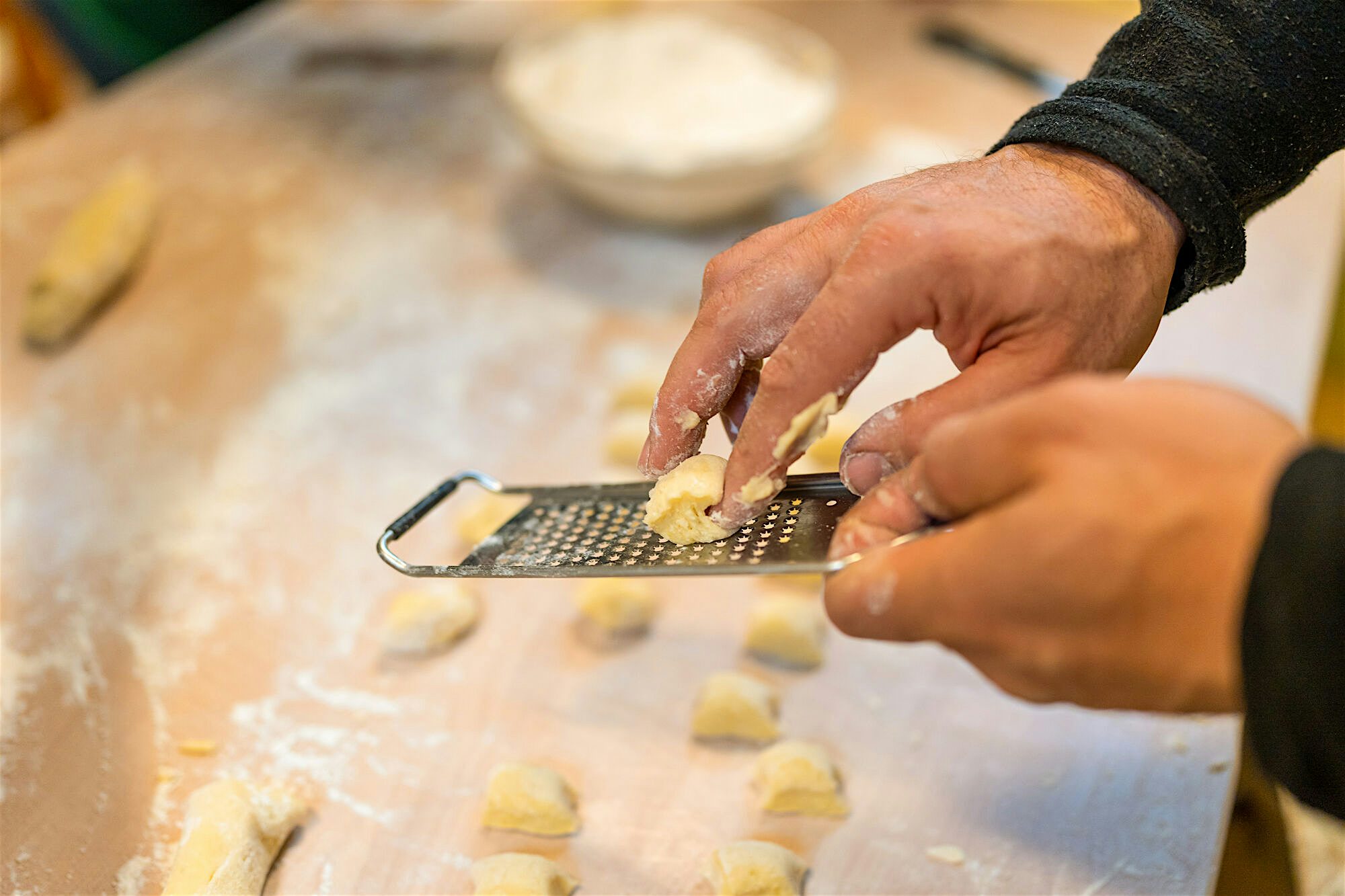 Close up shot of a chef making a traditional pasta recipe. They are demonstrating for a cooking class experience