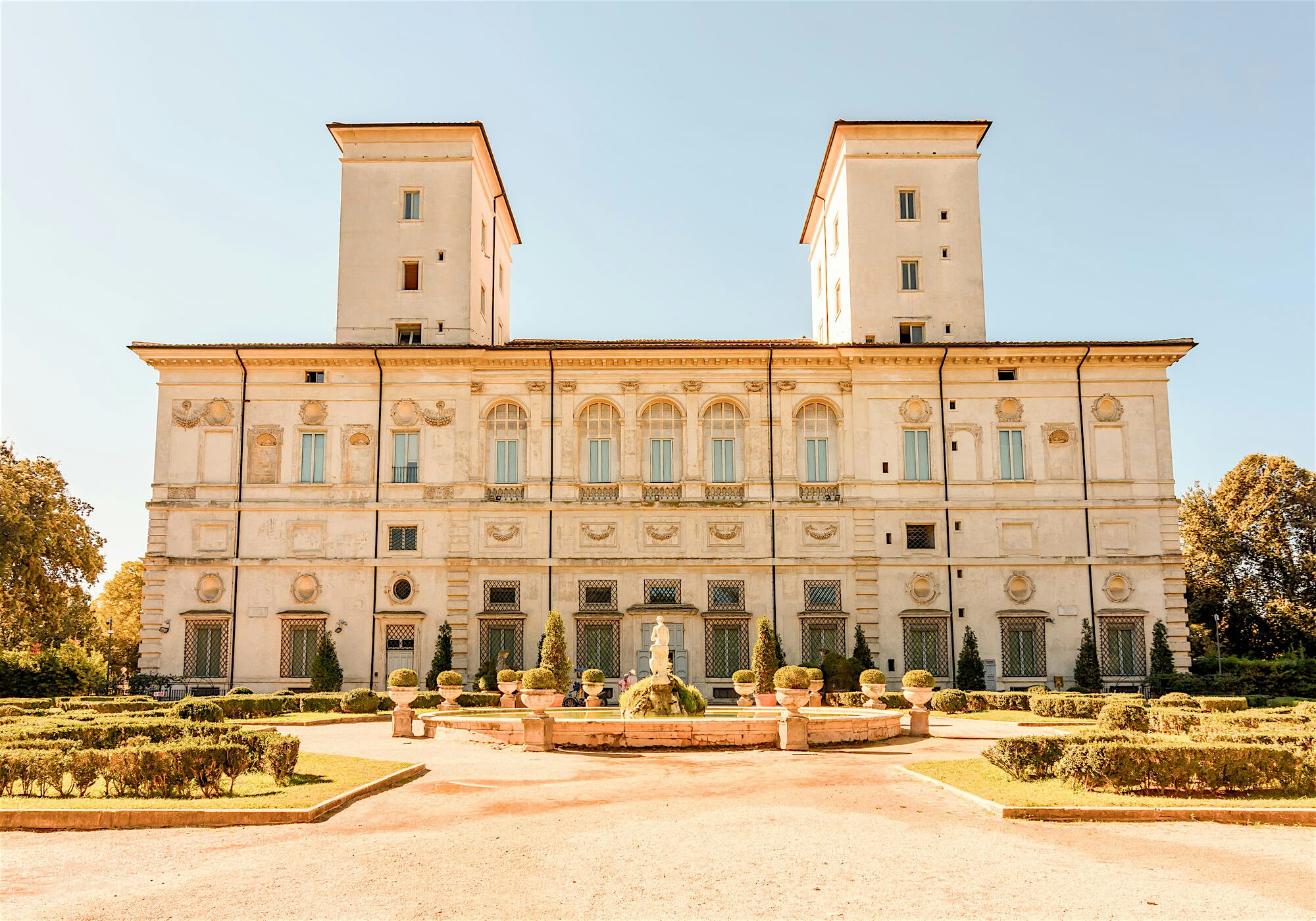 Grand Renaissance style home, ornate exterior, and a garden with a fountain in the center