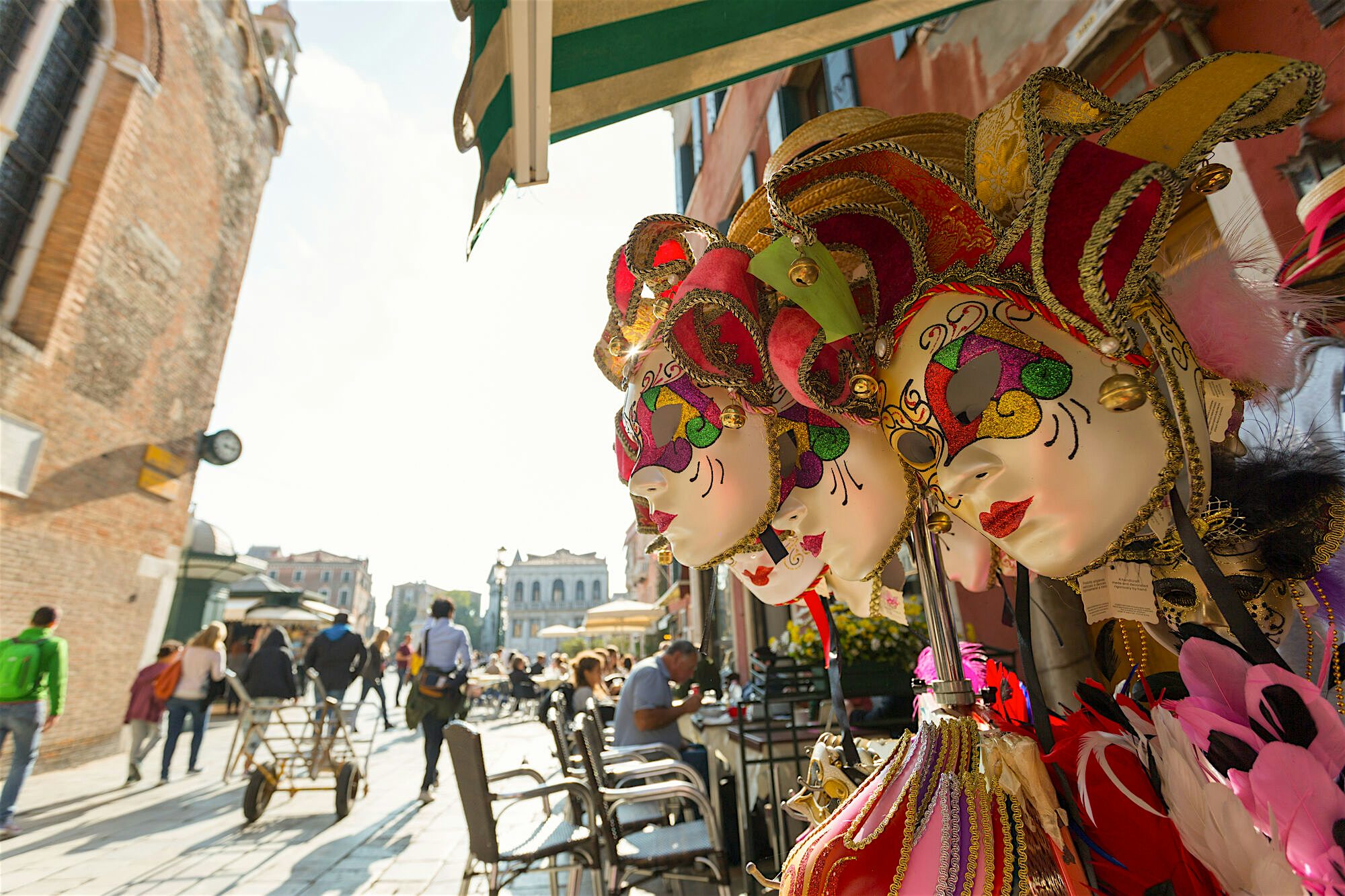 Local market in Venice, old town can be seen in the background, focussed on the traditional masks in one stall