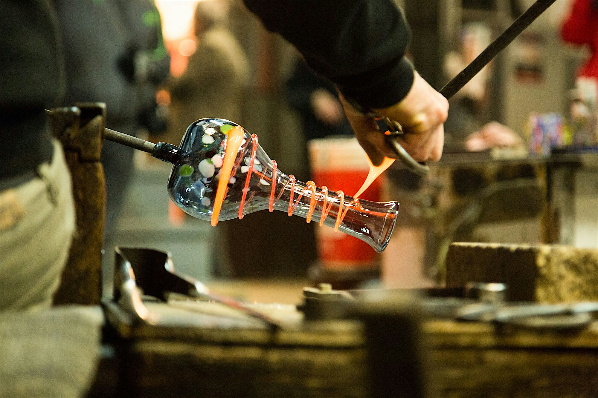 Traditional glass making workshop, decorating a jar with molten glass swirled around the edge  of the design.