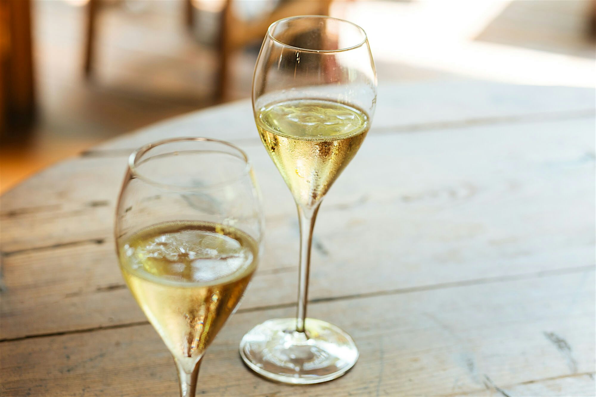 Two glasses of white wine, on an outdoor table