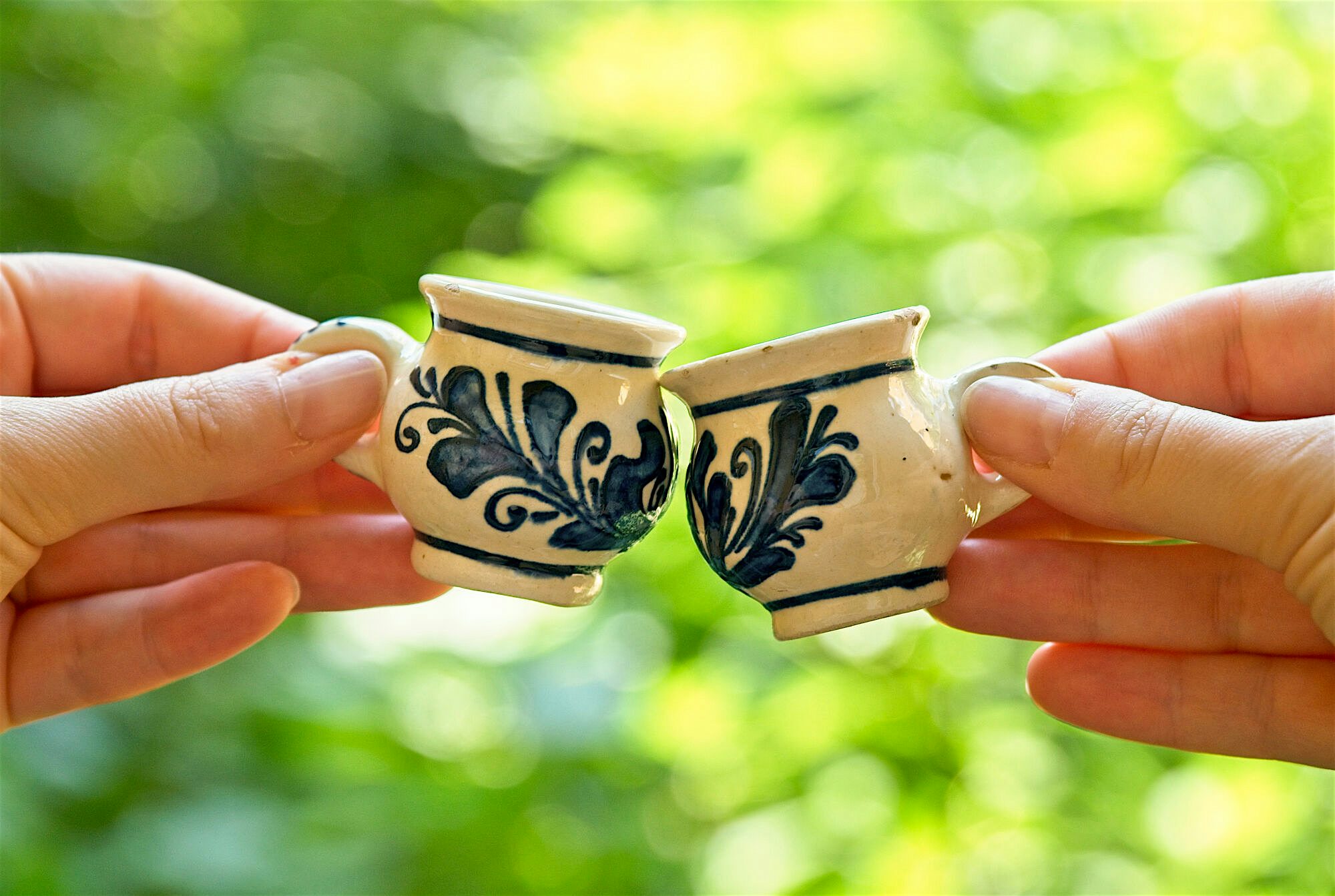 Two tea cups cheers-ing.