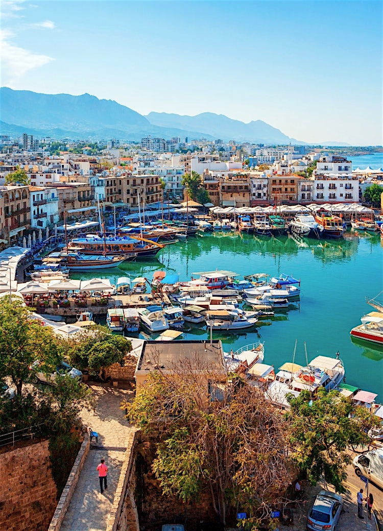 Kyrenia Harbour, North Cyprus, with a historic marina, yachts, Mediterranean coastline, and Kyrenia Mountains.