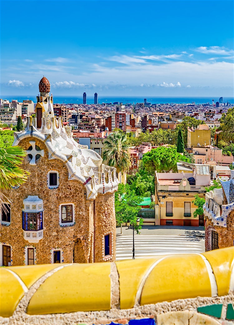 Barcelona skyline from Park Güell featuring Gaudí architecture, colourful mosaics, historic landmarks and Mediterranean city views.
