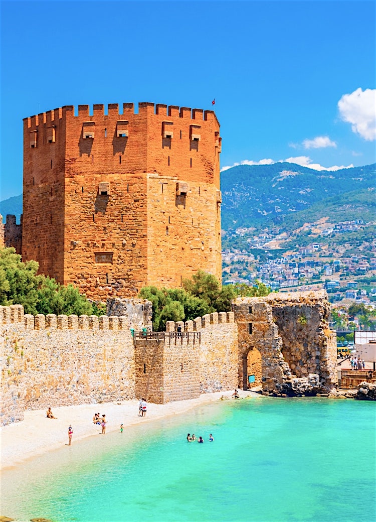 Antalya Harbour with historic Red Tower, turquoise Mediterranean waters, ancient castle walls and scenic Turkish coastline.