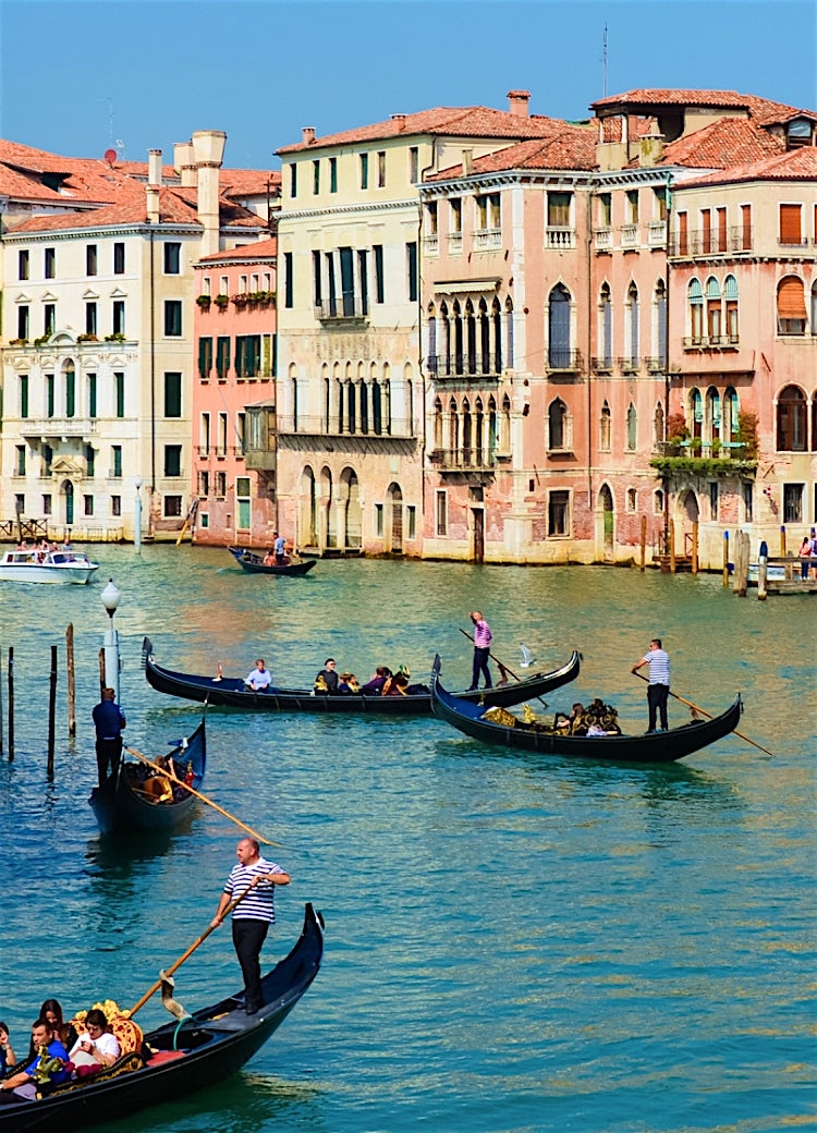 Venice Grand Canal with traditional gondolas, historic waterfront buildings and iconic Italian cityscape.