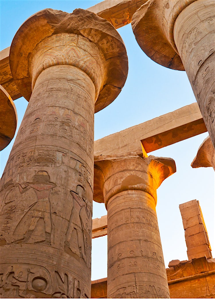 Ancient Egyptian temple columns with hieroglyphics, historic stone architecture and iconic archaeological landmark.