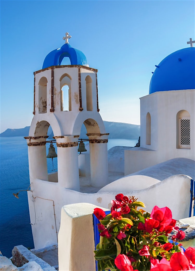 Iconic blue-domed church in Santorini overlooking the Aegean Sea, with whitewashed architecture and stunning coastal views.