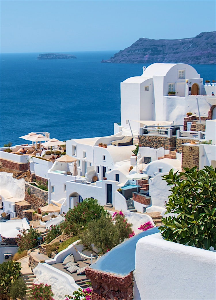 Whitewashed Santorini cliffside village overlooking the Aegean Sea, with luxury terraces, caldera views and iconic Cycladic architecture.