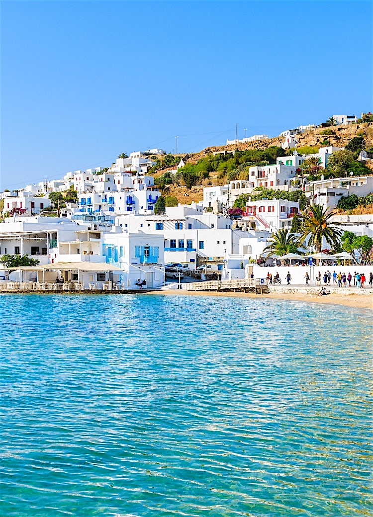 Mykonos waterfront with whitewashed buildings, seaside promenade, turquoise Aegean waters and traditional Cycladic architecture