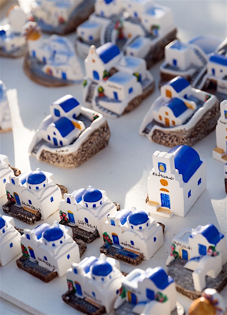 Santorini souvenir replicas featuring iconic blue-domed churches and whitewashed buildings on display.