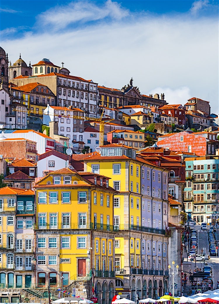 Colourful Porto cityscape with historic riverside buildings, terracotta rooftops, church towers, and classic Portuguese architecture in northern Portugal.