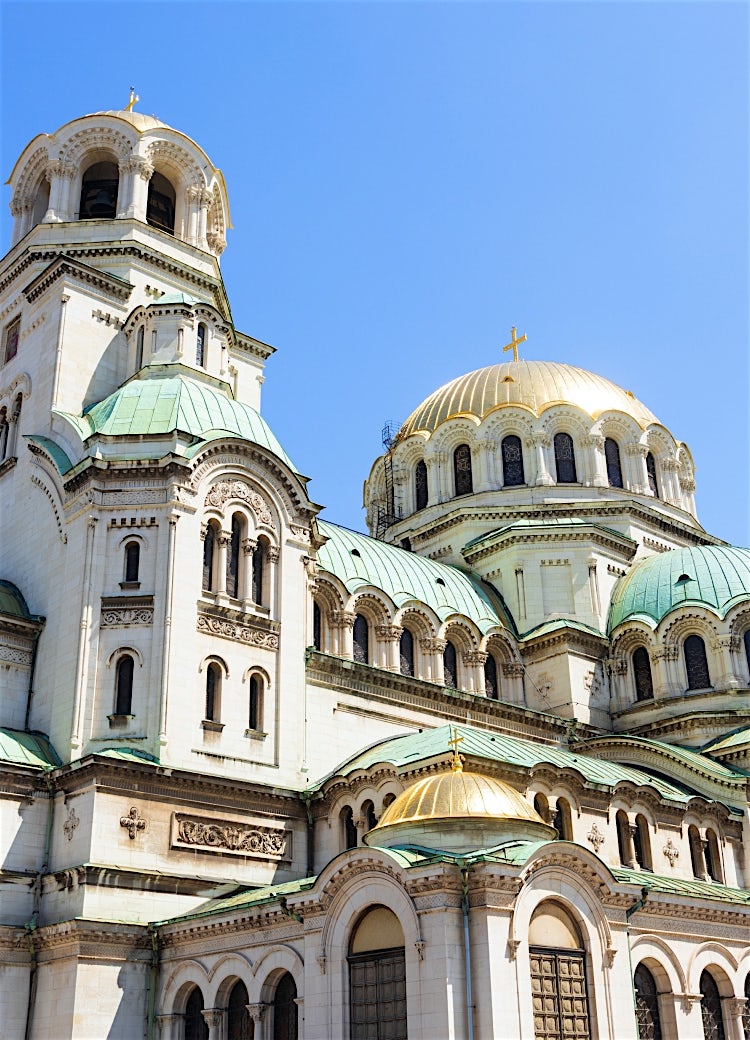 Sofia Alexander Nevsky Cathedral in Bulgaria, featuring golden domes, ornate Orthodox architecture, and a clear blue sky backdrop.