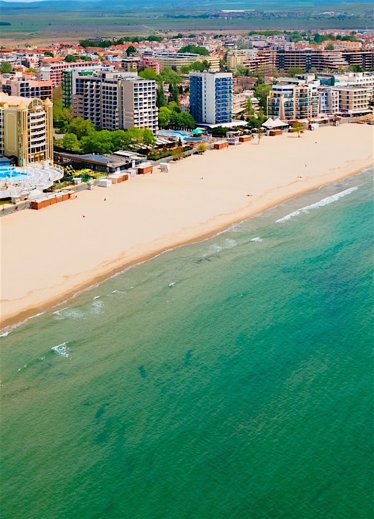 Sunny Beach, Bulgaria, aerial view of golden sandy coastline, beachfront hotels, and turquoise Black Sea waters along the popular resort shore.
