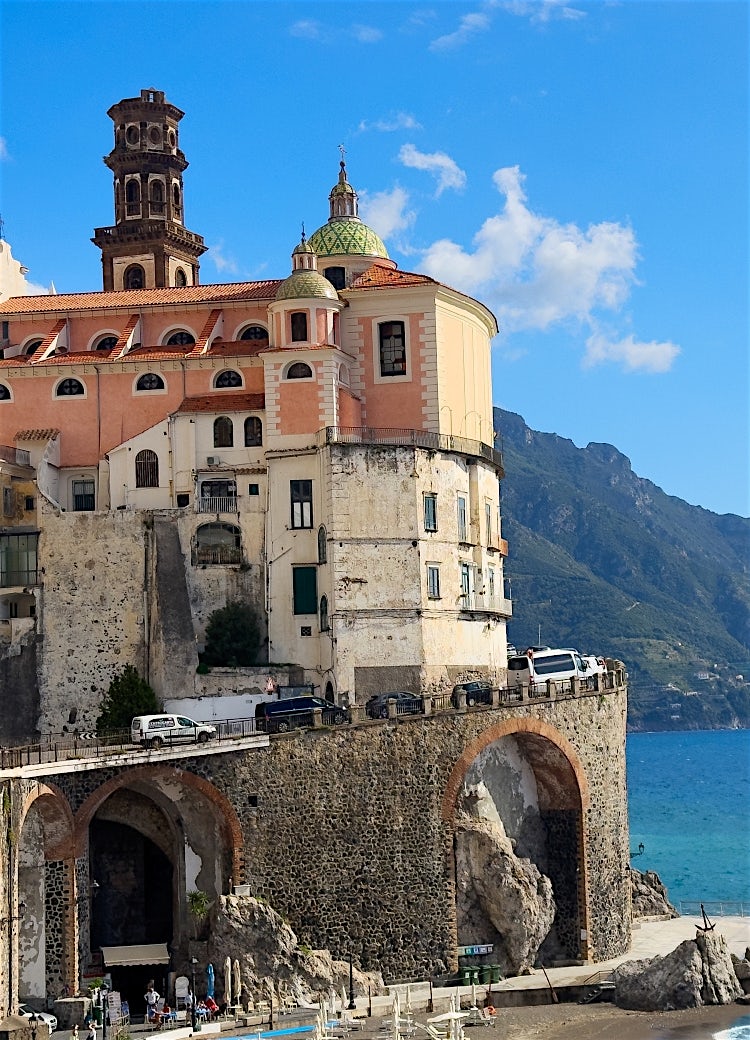 Amalfi Coast historic church overlooking rugged mountains, coastal village architecture and panoramic Italian seaside scenery.