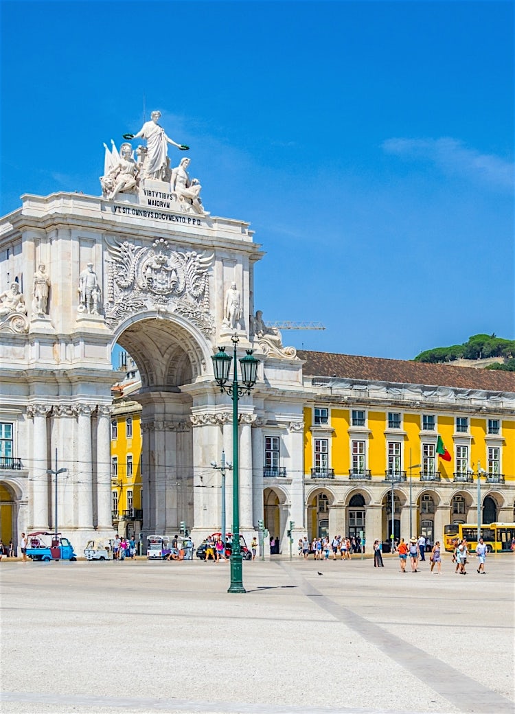 Praça do Comércio and Arco da Rua Augusta in Lisbon, Portugal, featuring historic yellow façades, grand neoclassical architecture and a bustling city square.