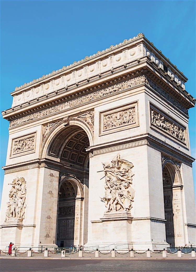 Arc de Triomphe in Paris, France, showcasing the iconic historic monument, neoclassical architecture and renowned city landmark against a clear blue sky.