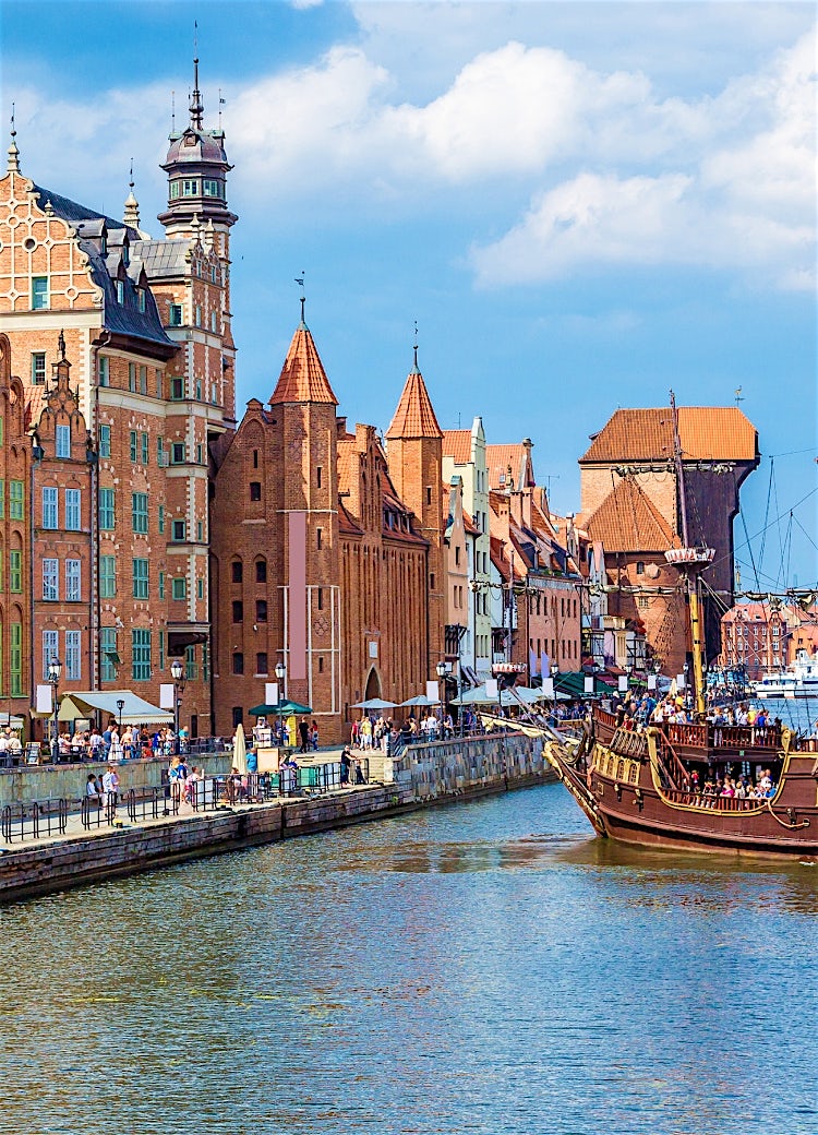 Gdańsk Old Town waterfront, Poland, with colourful historic townhouses, medieval architecture, and a traditional ship on the Motława River.