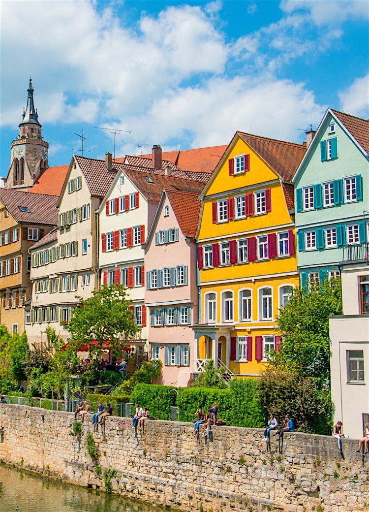 Colourful half-timbered houses along the Neckar River in Tübingen, Germany, with historic old town architecture and church tower.