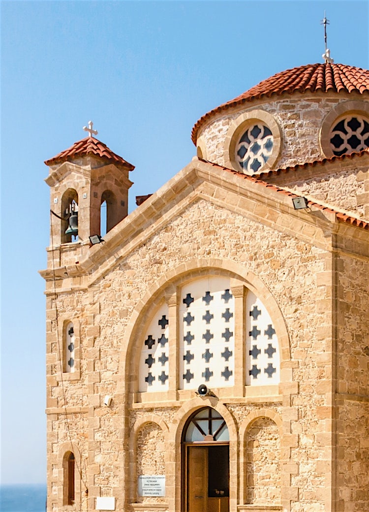 Paphos stone church with Byzantine architecture, bell tower, terracotta roof and traditional Cypriot heritage design.