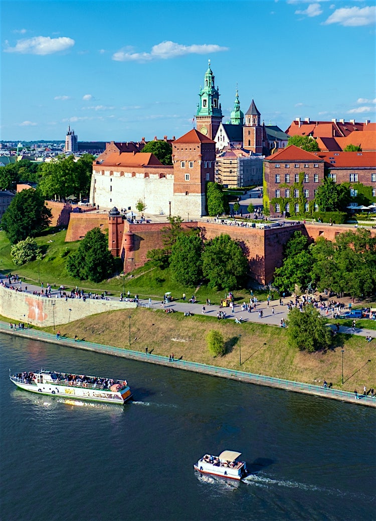 Wawel Castle overlooking the Vistula River in Kraków, featuring historic towers, medieval architecture and panoramic city views.