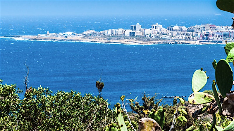 Qawra Malta coastal views with Mediterranean Sea, rocky shoreline and seaside resort town