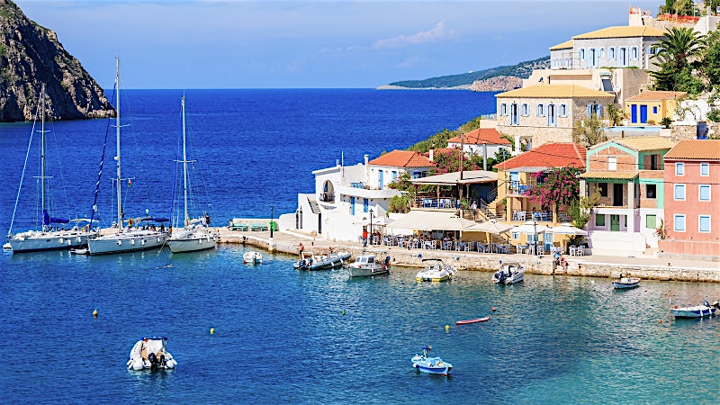 Colorful Assos village harbour with yachts and turquoise Ionian Sea, Kefalonia, Greece.