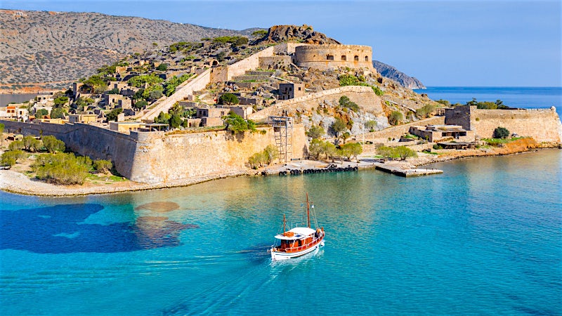Venetian fortress of Spinalonga Island with crystal-clear Mediterranean waters, Crete, Greece.