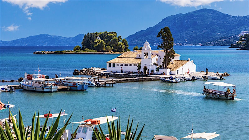 Vlacherna Monastery, boats and turquoise Ionian Sea, Corfu Island, Greece.