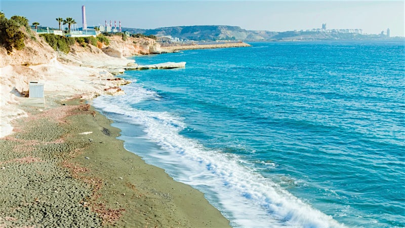 Mackenzie Beach coastline with turquoise Mediterranean Sea and limestone cliffs, Larnaca, Cyprus.