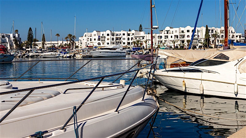 Luxury marina with yachts, waterfront promenade and whitewashed architecture, Port El Kantaoui, Tunisia.