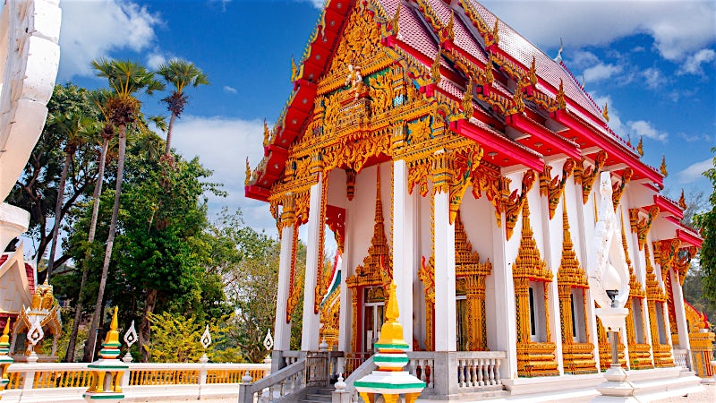 Ornate Buddhist temple with traditional Thai architecture and intricate golden details, Phuket, Thailand.