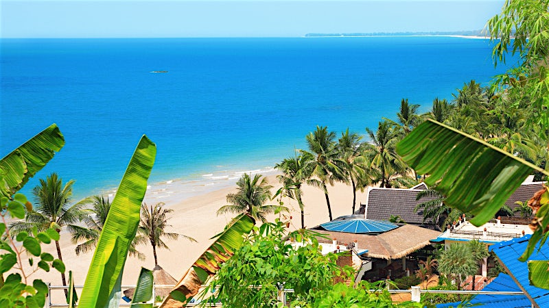 Palm-fringed beach with golden sand, tropical coastline and Andaman Sea views, Khao Lak, Thailand.