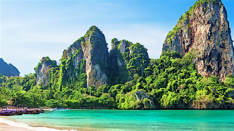 Limestone karst cliffs overlooking turquoise sea and tropical beach, Krabi, Thailand.