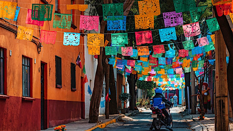 Historic street decorated with colourful papel picado banners in Mexico City, Mexico.