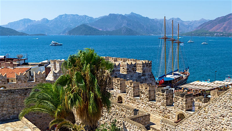 Marmaris Turkey marina with historic castle walls, sailing boats and Mediterranean bay