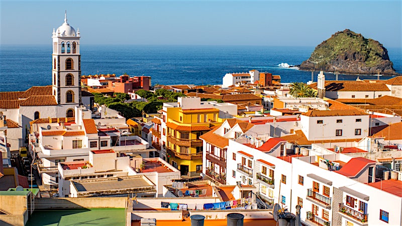 Canary Islands coastal town with whitewashed buildings, church tower and Atlantic Ocean views