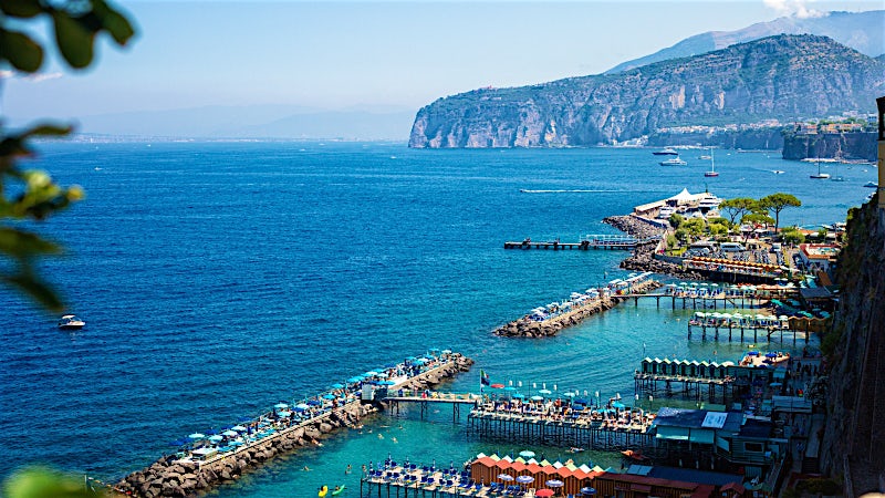 Sorrento Italy coastline with turquoise sea, waterfront lidos and dramatic cliffside scenery