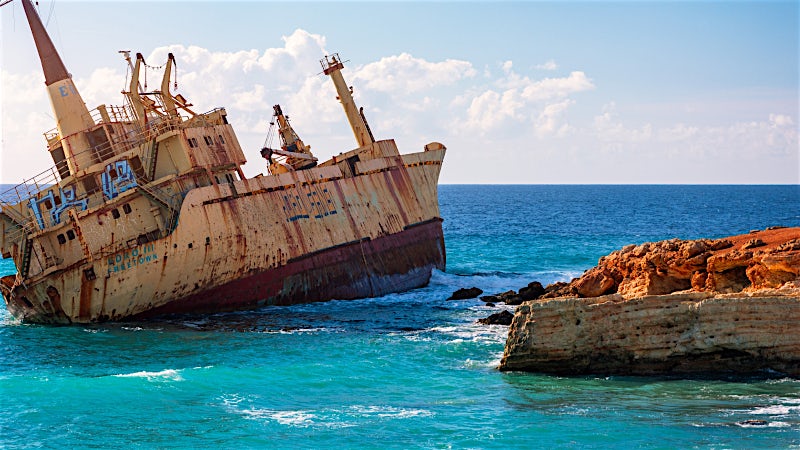 EDRO III shipwreck on rocky coastline with turquoise Mediterranean Sea, Cyprus.