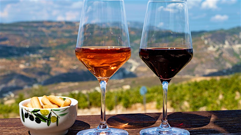 Red and rosé wine tasting overlooking vineyards and countryside, Cyprus wine region.