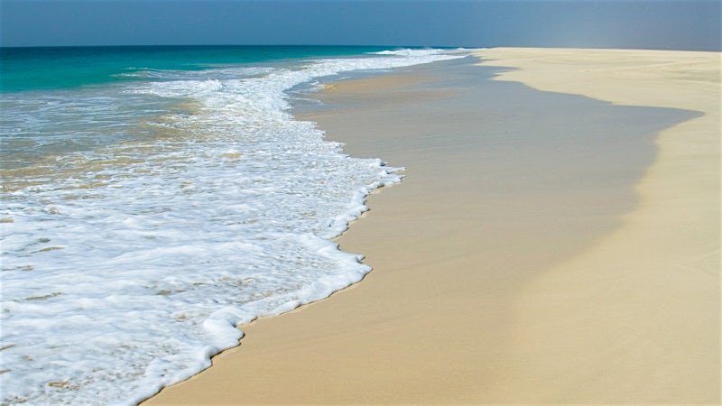 Pristine Praia de Atalanta beach with white sand shoreline and turquoise Atlantic waves in Cape Verde.