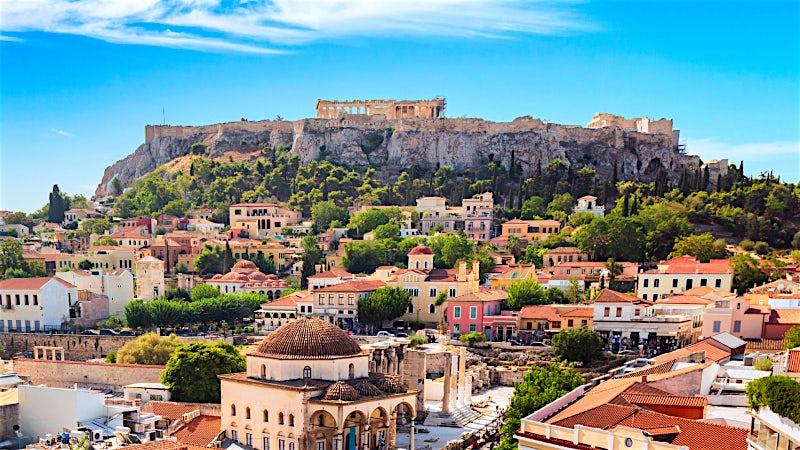 Athens cityscape with the Acropolis and Parthenon overlooking historic Greek architecture.