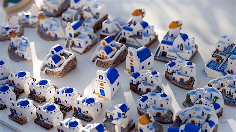Santorini souvenir miniatures featuring iconic whitewashed buildings and blue-domed churches.