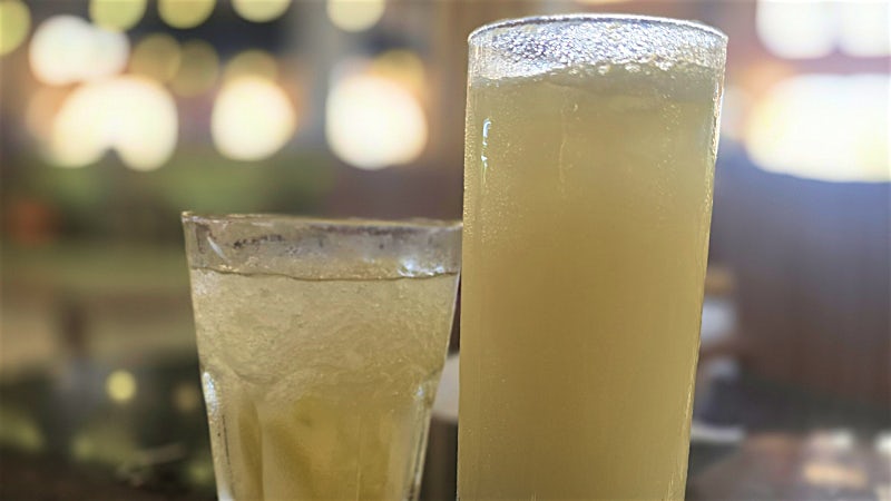 Traditional Cape Verde cocktail drinks served at a lively beachfront bar at night.